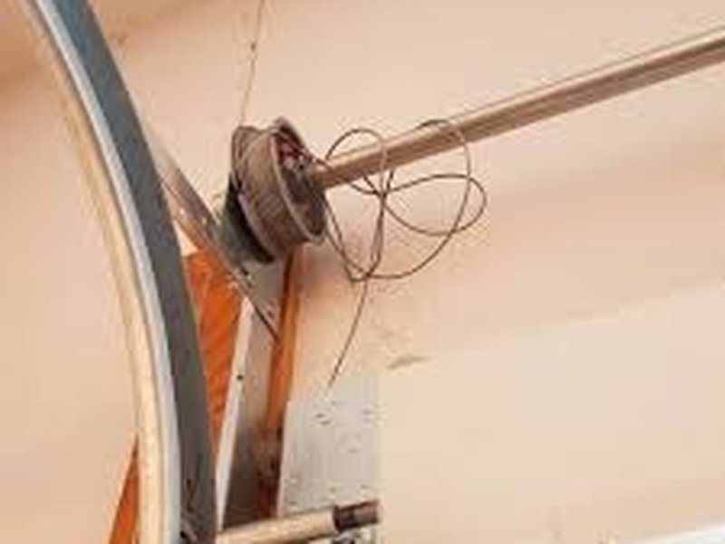Cable and drum hardware at the side of a garage door, close view