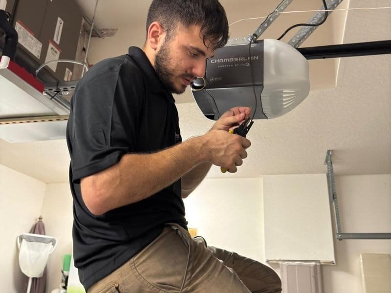 Technician servicing the head unit of a garage door opener