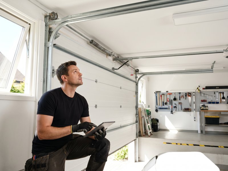 Technician holding a tablet beneath an overhead door