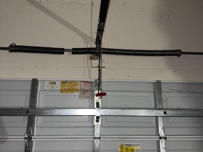 Torsion spring and steel shaft above a garage door, close view
